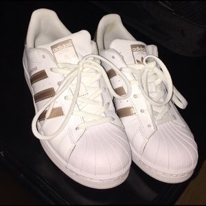 Gold and white Adidas Superstars